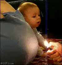 Baby touches pregnant belly lit by lighter