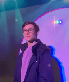 Man in glasses smiling under stage lights