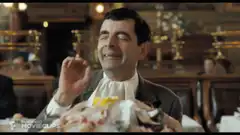 Mr. Bean eating chicken with delight
