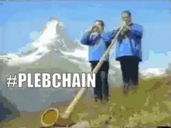 Two men playing alphorns in front of a mountain