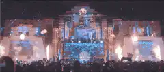 DJ performing on massive stage with pyrotechnics