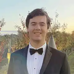 Man in tuxedo smiling outdoors