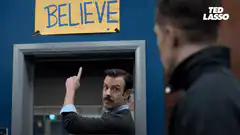 Jason Sudeikis points to BELIEVE sign