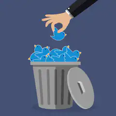 Hand dropping Twitter bird into trash can