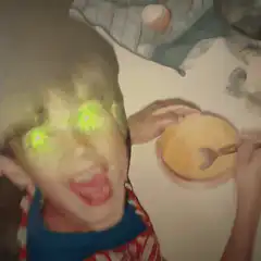Boy with glowing green eyes eating cereal