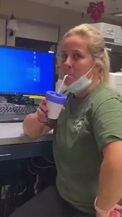 Woman drinks from cup with purple glove