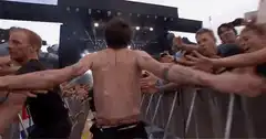 shirtless man crowd surfing