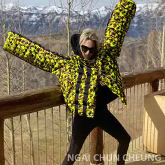Woman in neon camo jacket posing on deck
