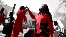 Two men in red doing a handshake