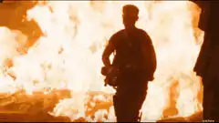 Soldier walking away from explosion