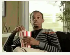 Man eating popcorn and looking bored