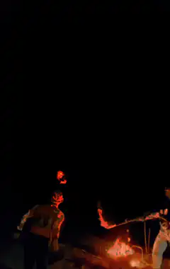 Glowing red face over campfire