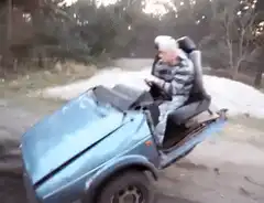 Man driving a blue car with a chair