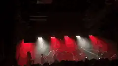 band performing on stage with red and white lights