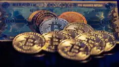 Bitcoin coins on hundred dollar bill