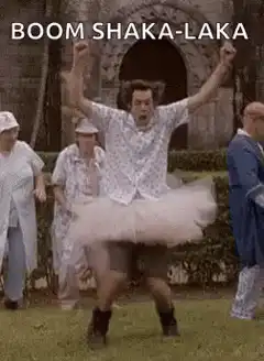 Man in tutu dancing with arms raised