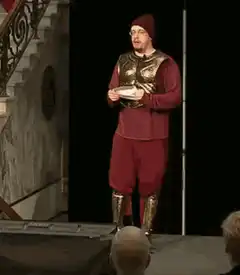 Man in red outfit waving bye bye