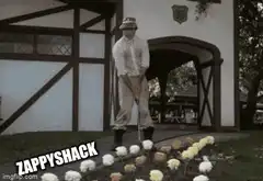 man swings golf club at flowers