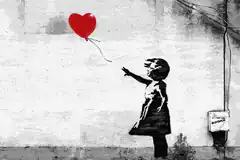 Girl reaching for red heart balloon