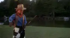 Cowboy turns and smiles with a stick
