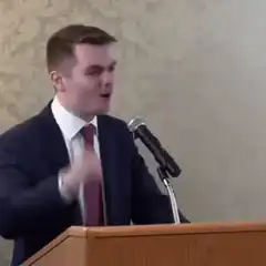Man in suit shouting at podium