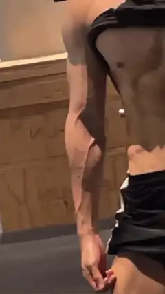 Muscular man flexing in gym mirror
