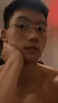 Shirtless man removes glasses and flips off camera